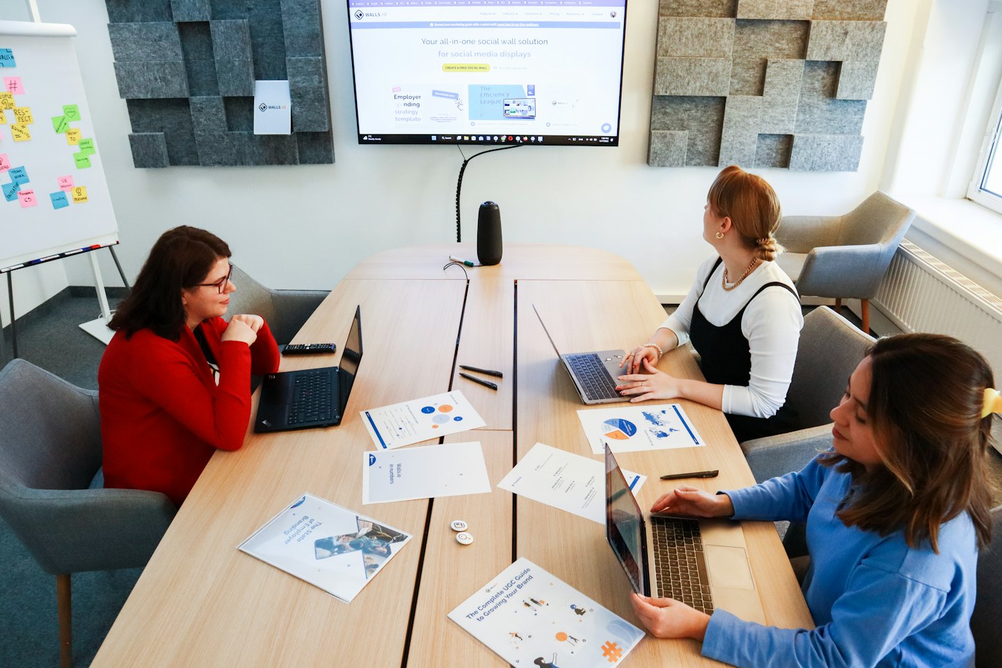 Drie vrouwen werken samen aan laptops aan een kantoortafel.